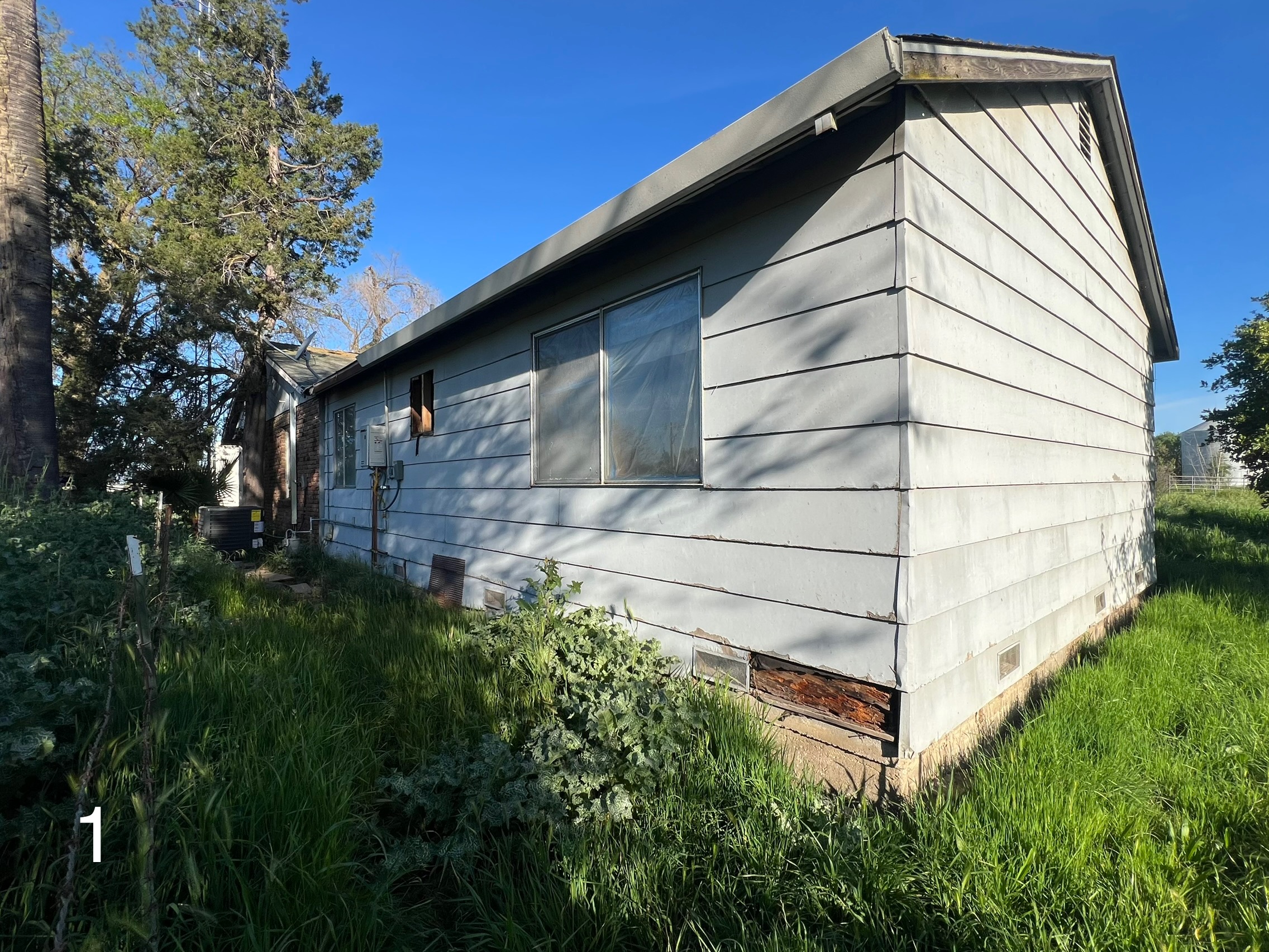 Before: Weathered peeling siding on the side elevation of the Yuba City home