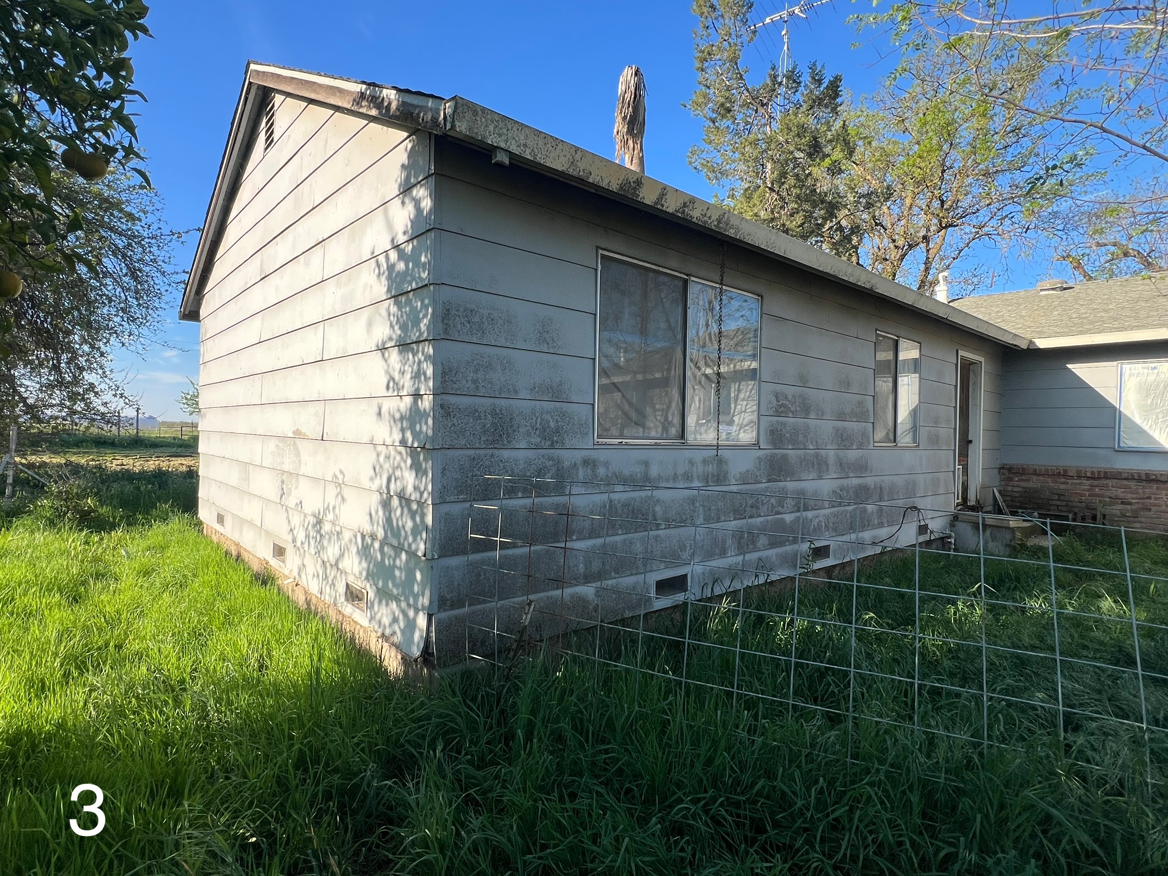 Before: Damaged siding on the side and rear corner of the Yuba City home