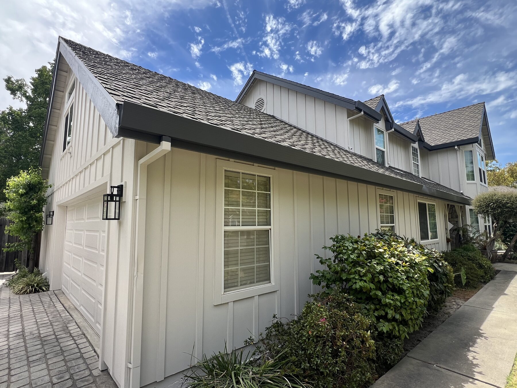 Fresh white board and batten siding with charcoal trim on a two-story home