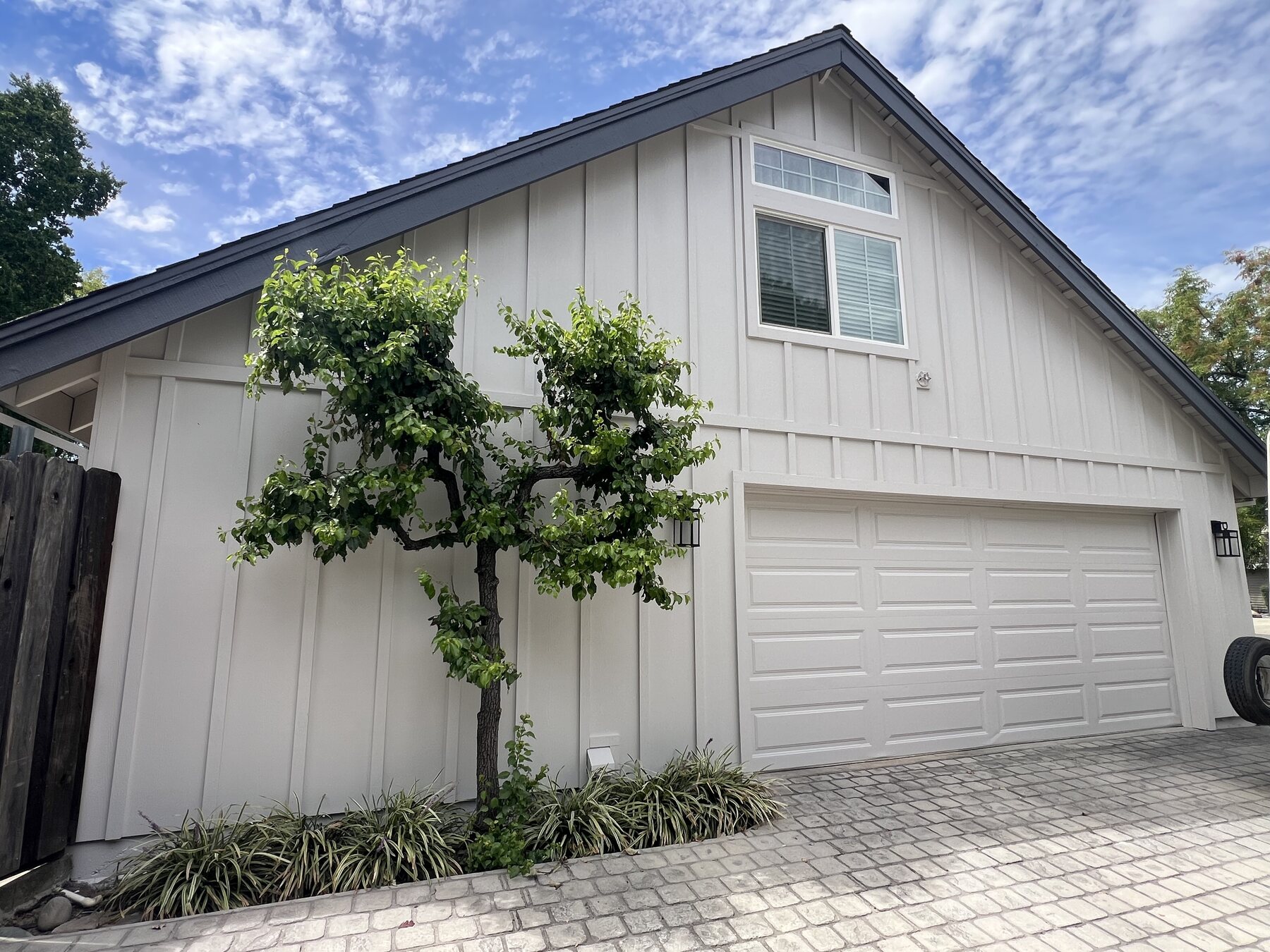 White board and batten siding and detailed gable trim above a garage